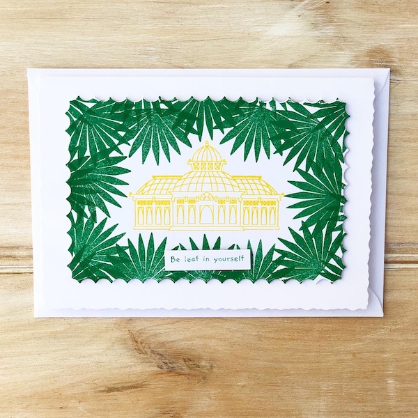 Bright green and yellow stamped handmade card featuring a palm house surrounded by a border of tropical leaves